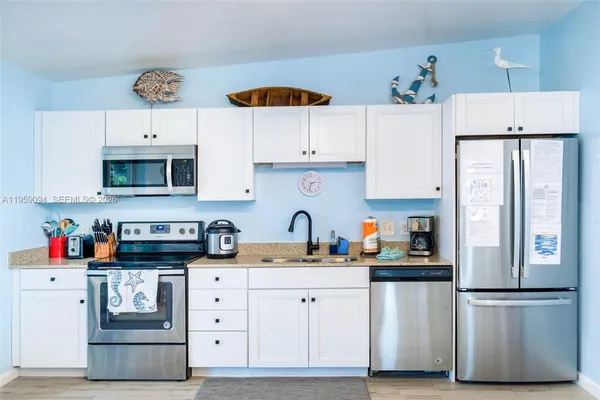 a kitchen with stainless steel appliances a refrigerator sink and cabinets