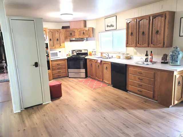 a kitchen with stainless steel appliances kitchen island granite countertop a refrigerator and a sink