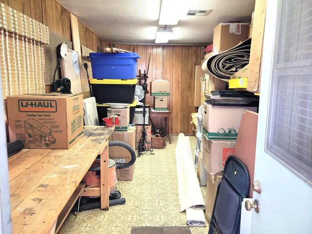 a view of a house with a floor to ceiling window and potted plants