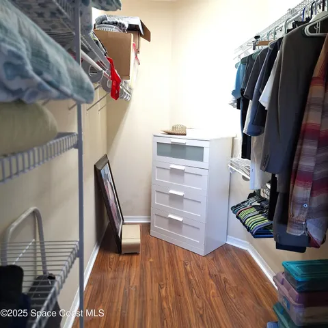 a view of walk in closet with clothes and shoes