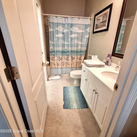 a bathroom with a sink a toilet a mirror and a shower