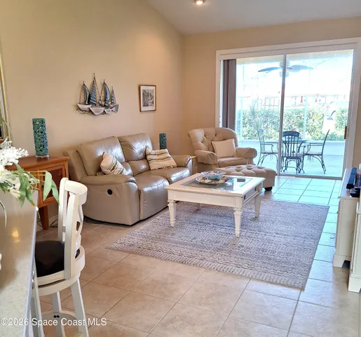 a living room with furniture and a floor to ceiling window