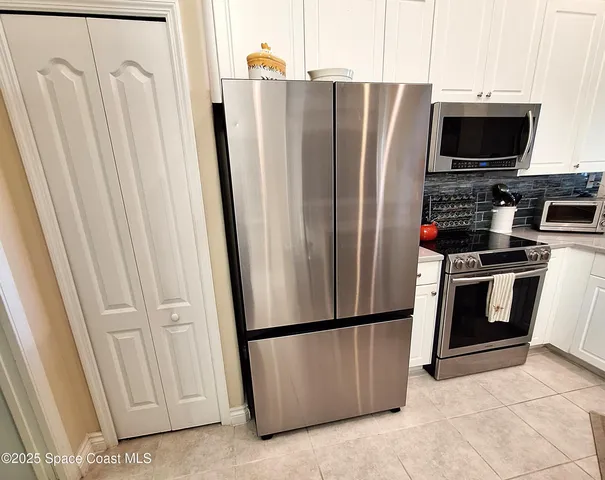 a metallic refrigerator freezer sitting in a kitchen