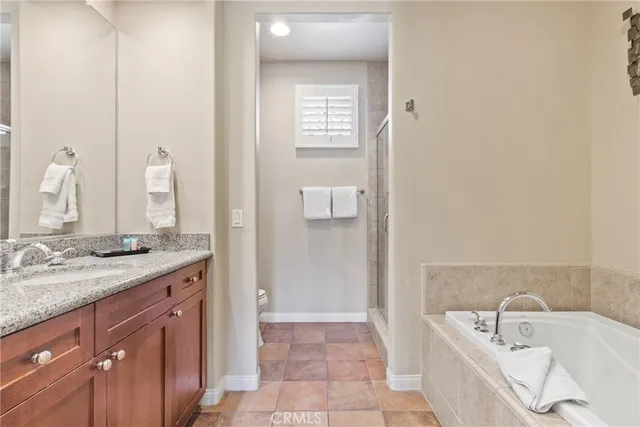 a bathroom with a granite countertop sink a bathtub and mirror