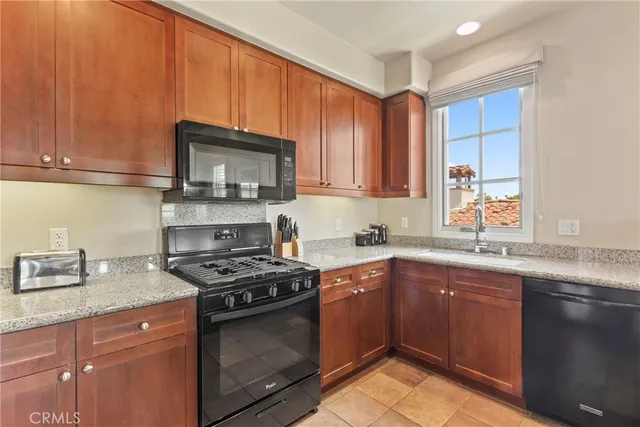 a kitchen with granite countertop a sink stove and cabinets