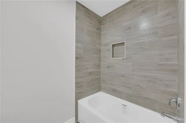 a bathroom with a white bath tub and a shower