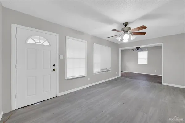 an empty room with wooden floor and window