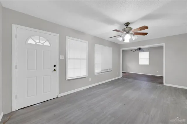 an empty room with wooden floor and window