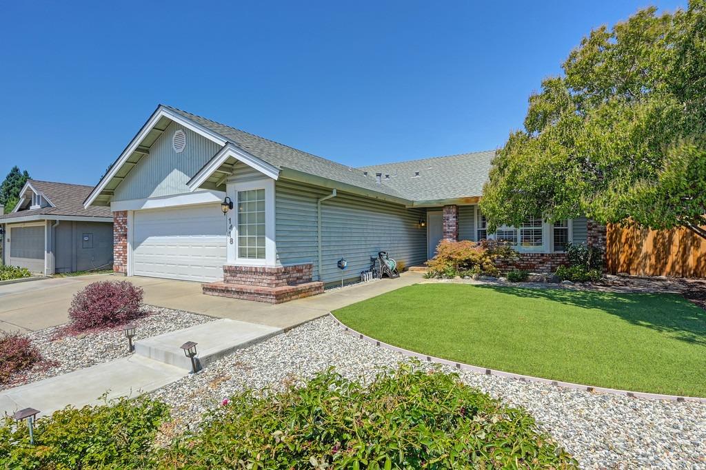 a front view of a house with a garden and yard