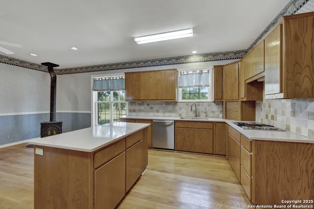 a kitchen with a sink cabinets and wooden floor