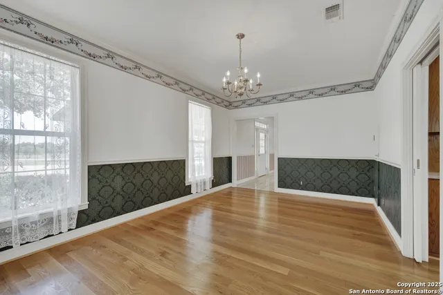 a view of a livingroom with a fireplace wooden floor and chandelier