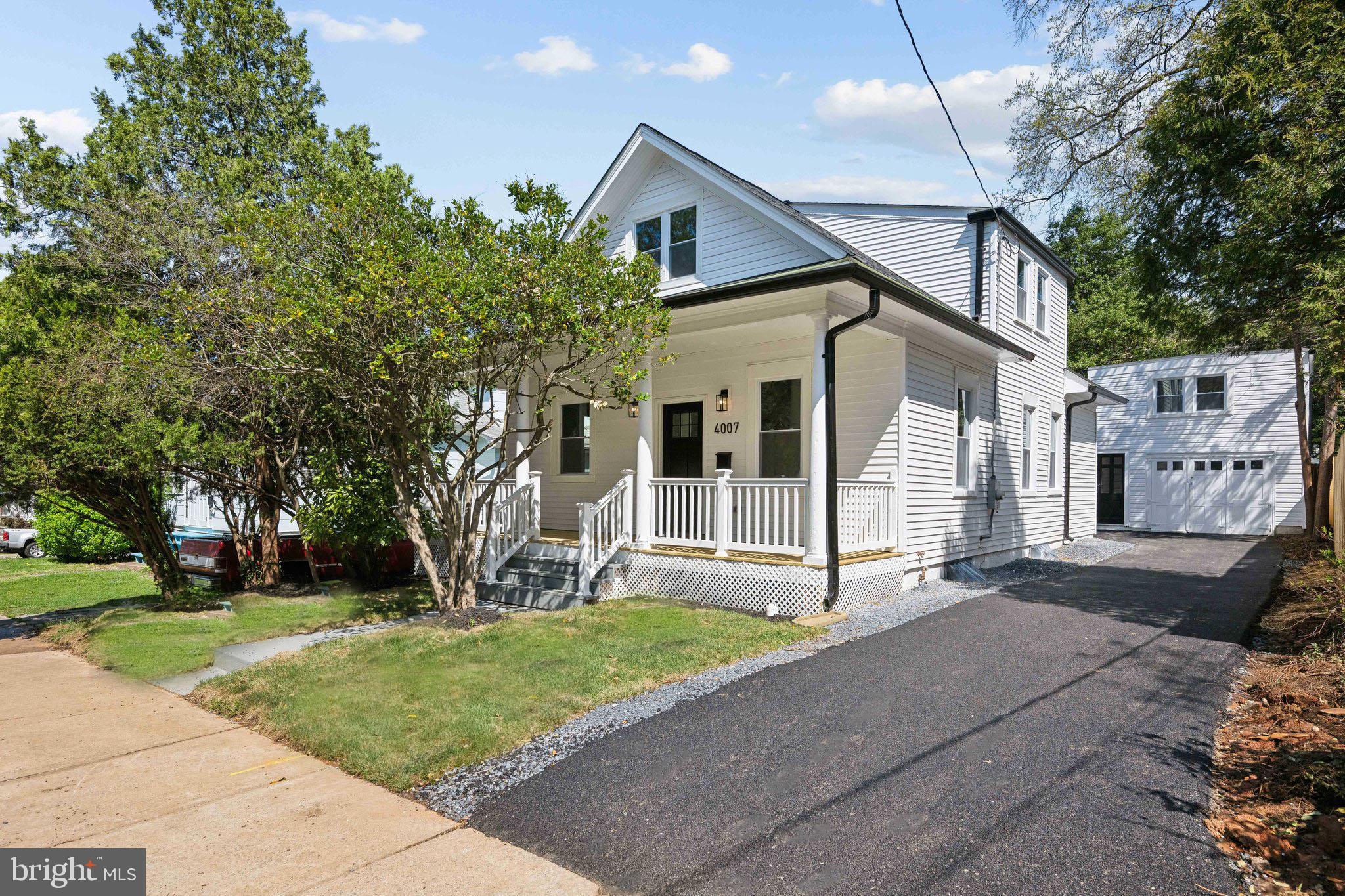 a white house that has tree in front of it
