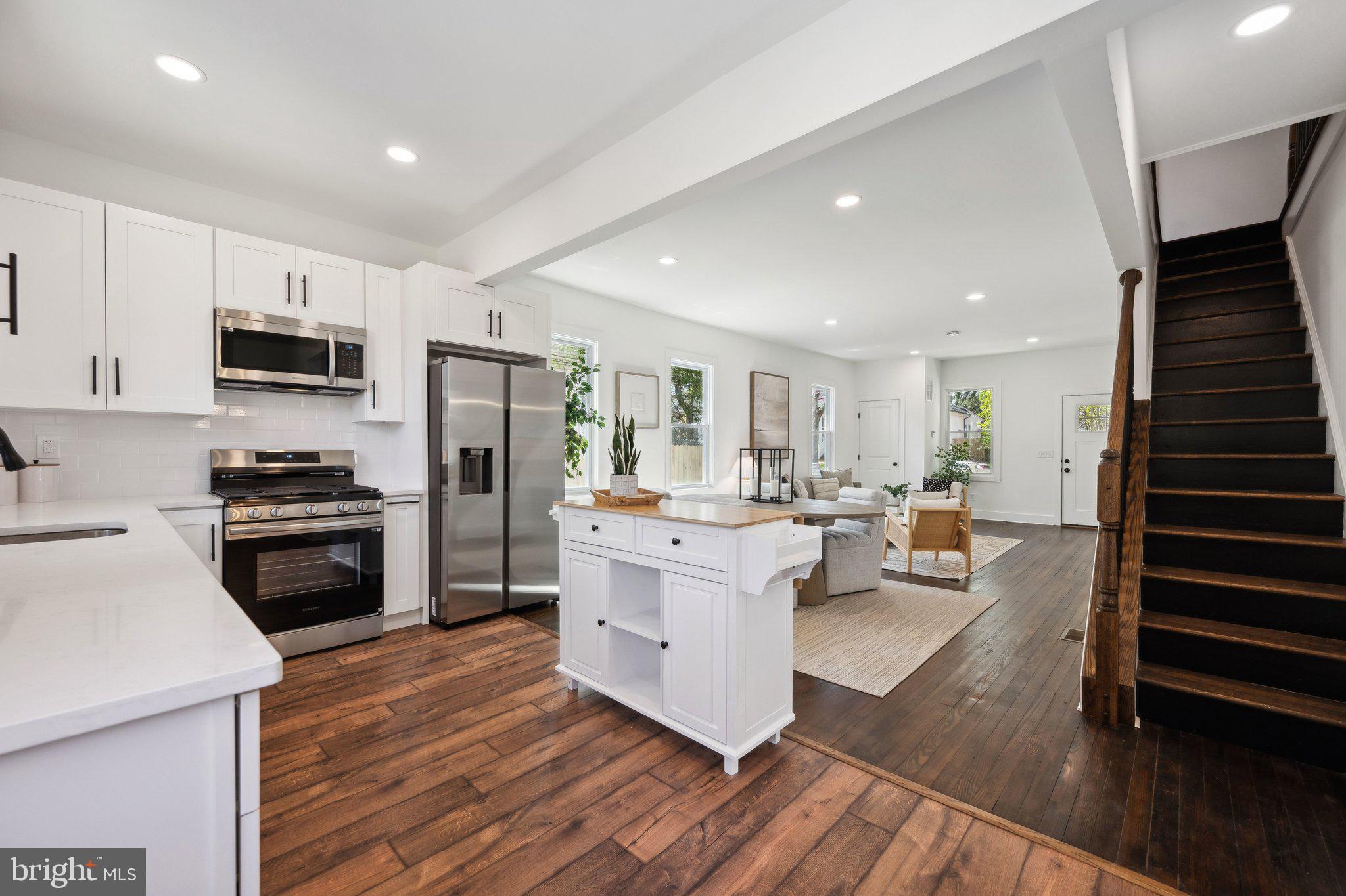 4007 35th Street Mount Rainier, MD 20712 - Photo 11 of 49 a kitchen with stainless steel appliances a stove a sink a refrigerator white cabinets and wooden floor