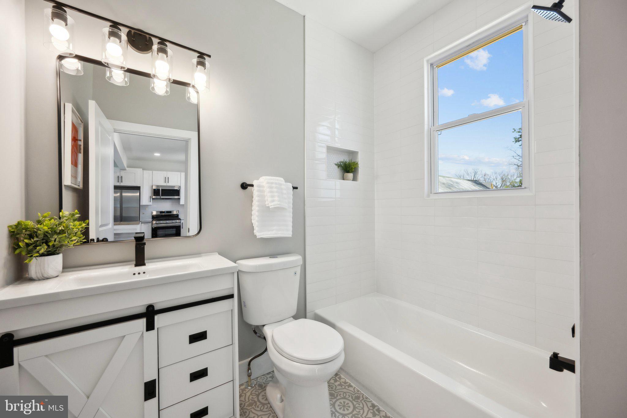 4007 35th Street Mount Rainier, MD 20712 - Photo 12 of 49 a bathroom with a granite countertop sink toilet and shower