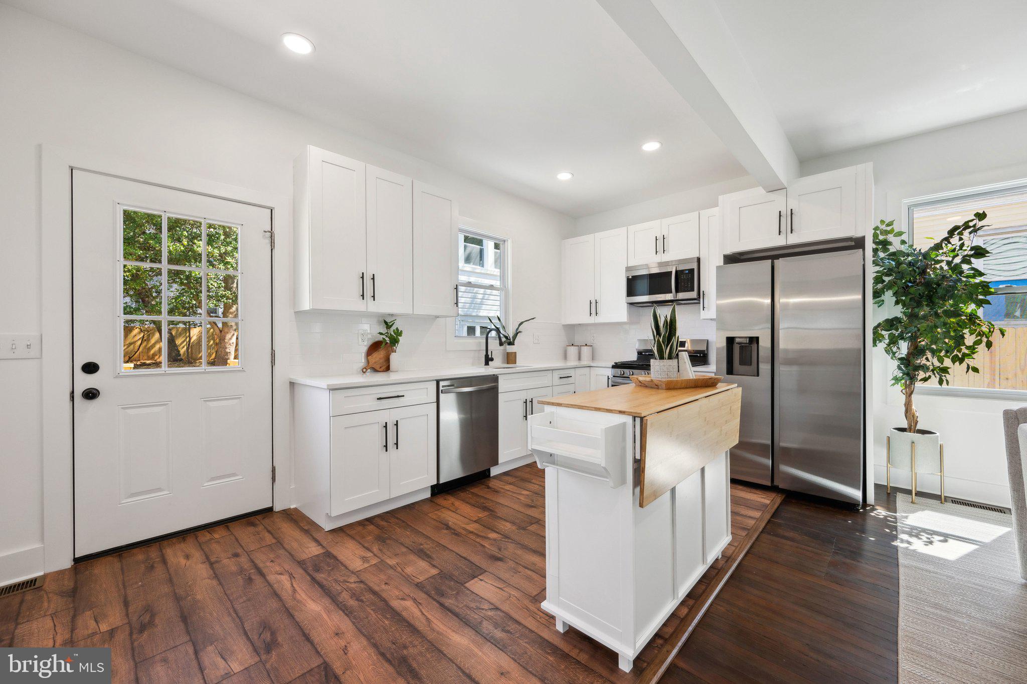 4007 35th Street Mount Rainier, MD 20712 - Photo 9 of 49 a kitchen with white cabinets and white appliances