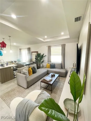 a living room with furniture kitchen view and a window