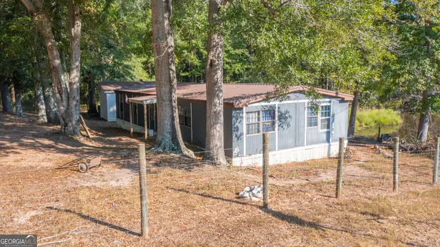 a view of a house with a small yard and large tree