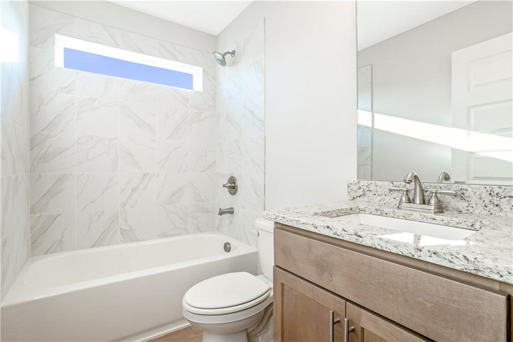 2596 Parkside Way Gainesville, GA 30507 - Photo 23 of 33 a bathroom with a granite countertop sink a toilet and bathtub