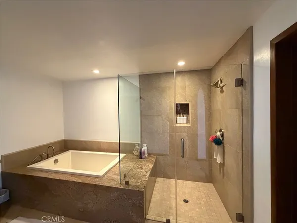 a bathroom with a tub a sink and mirror