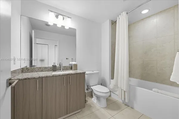a bathroom with a granite countertop sink mirror vanity and toilet