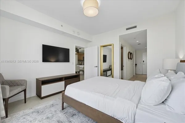 a bedroom with a bed and a flat screen tv