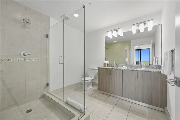 a bathroom with a shower a sink and mirror