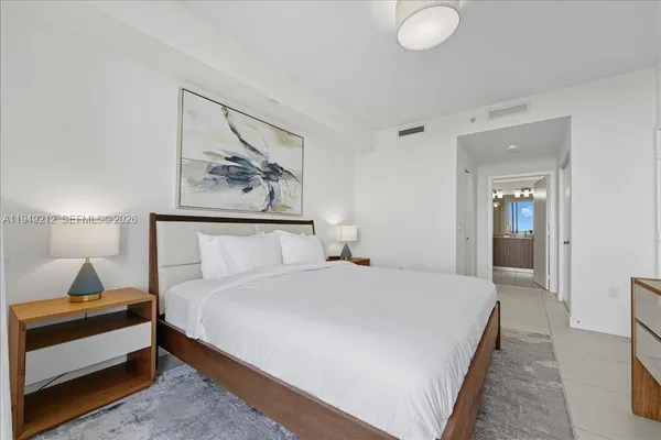 a bedroom with a bed and a lamp