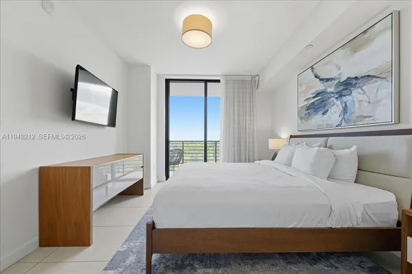 a bedroom with a bed and painting on the wall