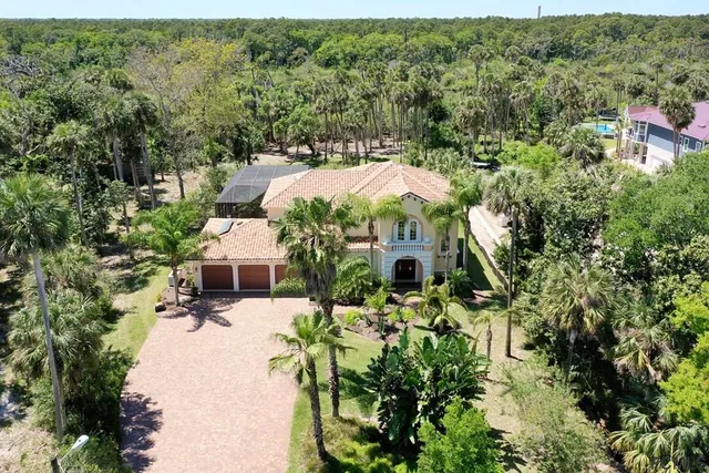 an aerial view of residential house with outdoor space and trees all around
