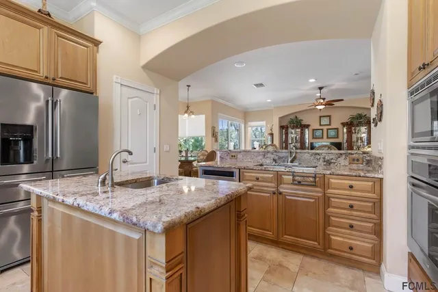 a kitchen with stainless steel appliances granite countertop a sink and a refrigerator
