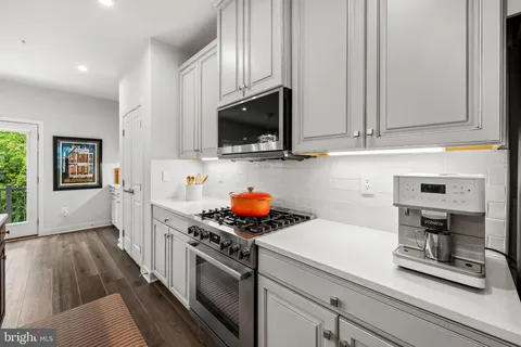 a kitchen with stainless steel appliances a stove microwave and sink