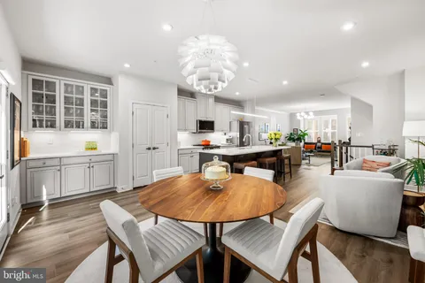 a dining room filled chandelier and wooden floor