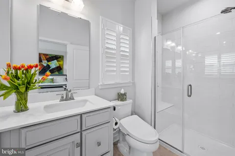 a bathroom with a sink a toilet and a large mirror