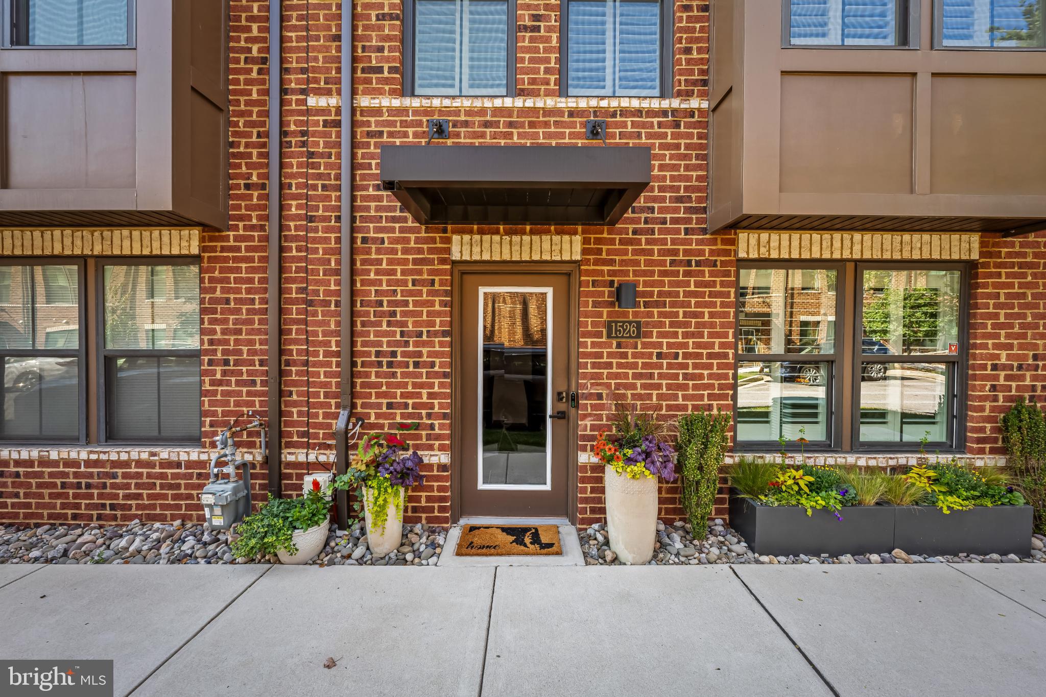 1526 Lowman Street Baltimore, MD 21230 - Photo 39 of 40 Charming brick facade with vibrant greenery.