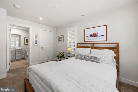 a bedroom with a bed and a painting on the wall