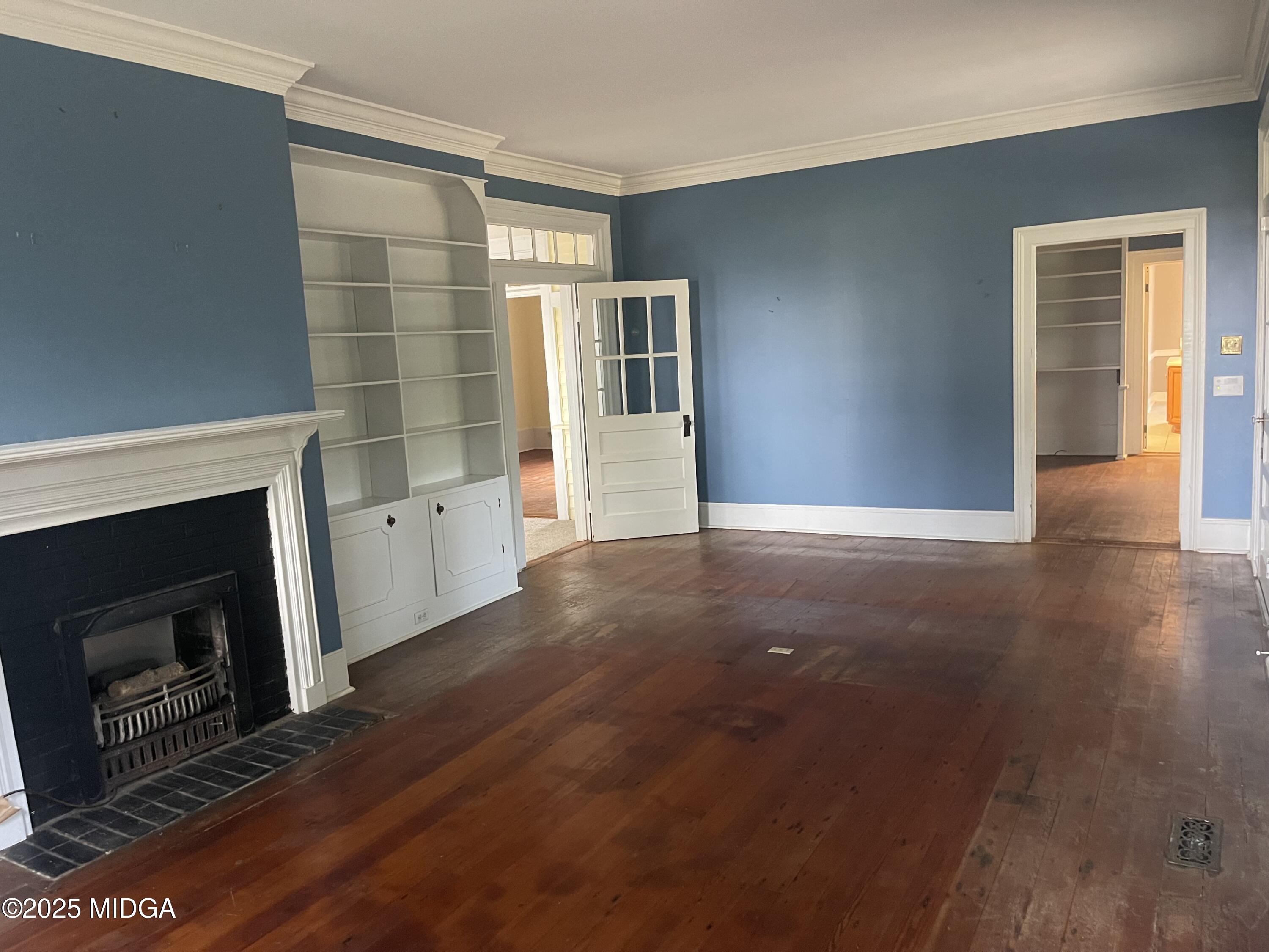 307 Woolfolk Road Fort Valley, GA 31030 - Photo 20 of 62 a view of an empty room with wooden floor fireplace and a window