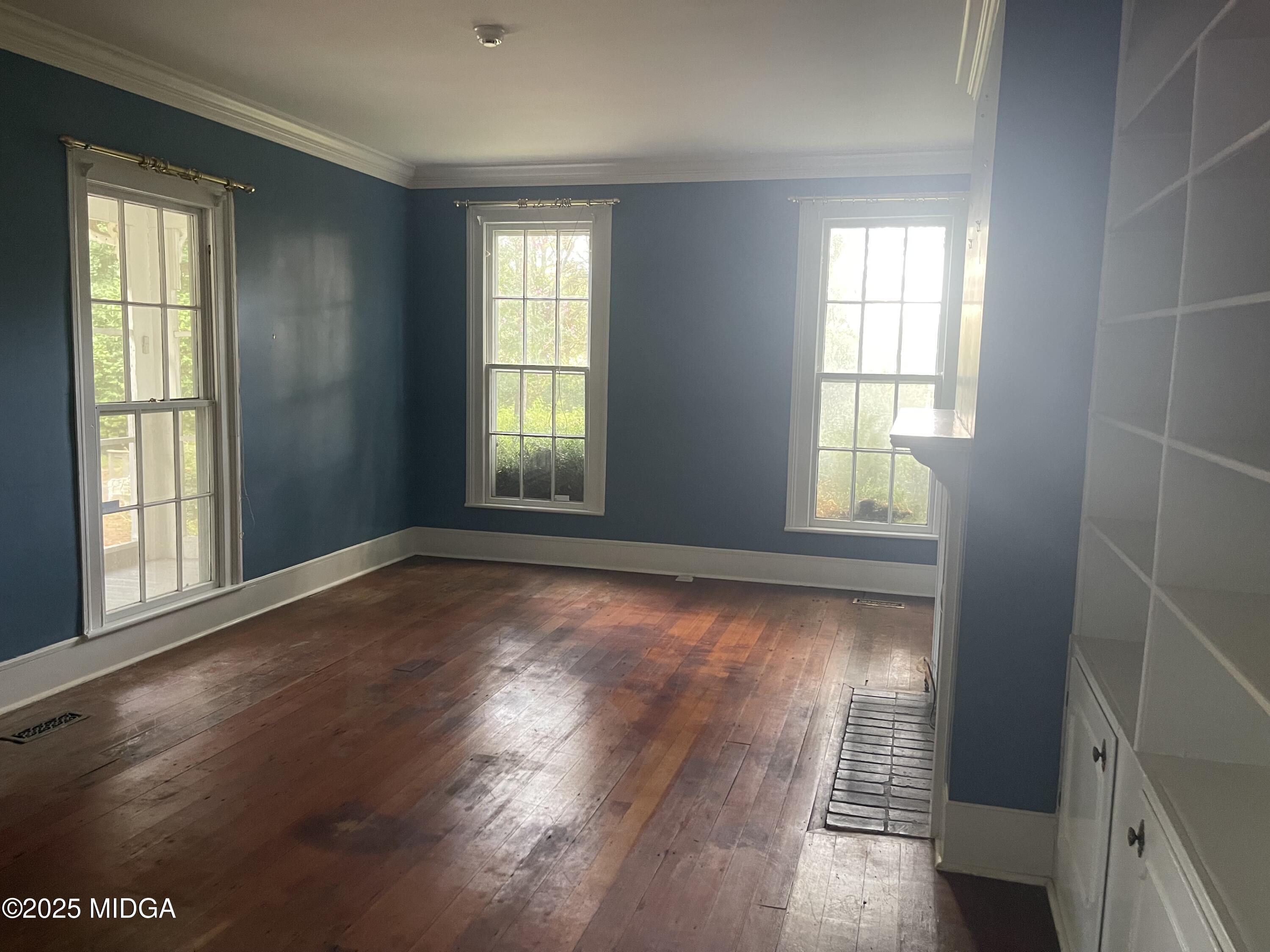307 Woolfolk Road Fort Valley, GA 31030 - Photo 21 of 62 an empty room with wooden floor and windows