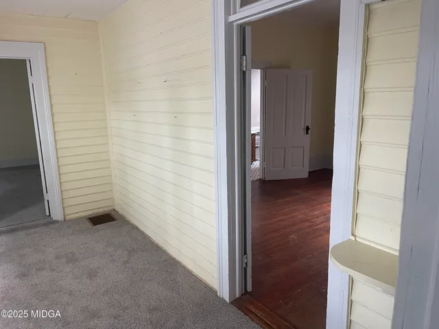 an empty room with wooden floor and cabinet