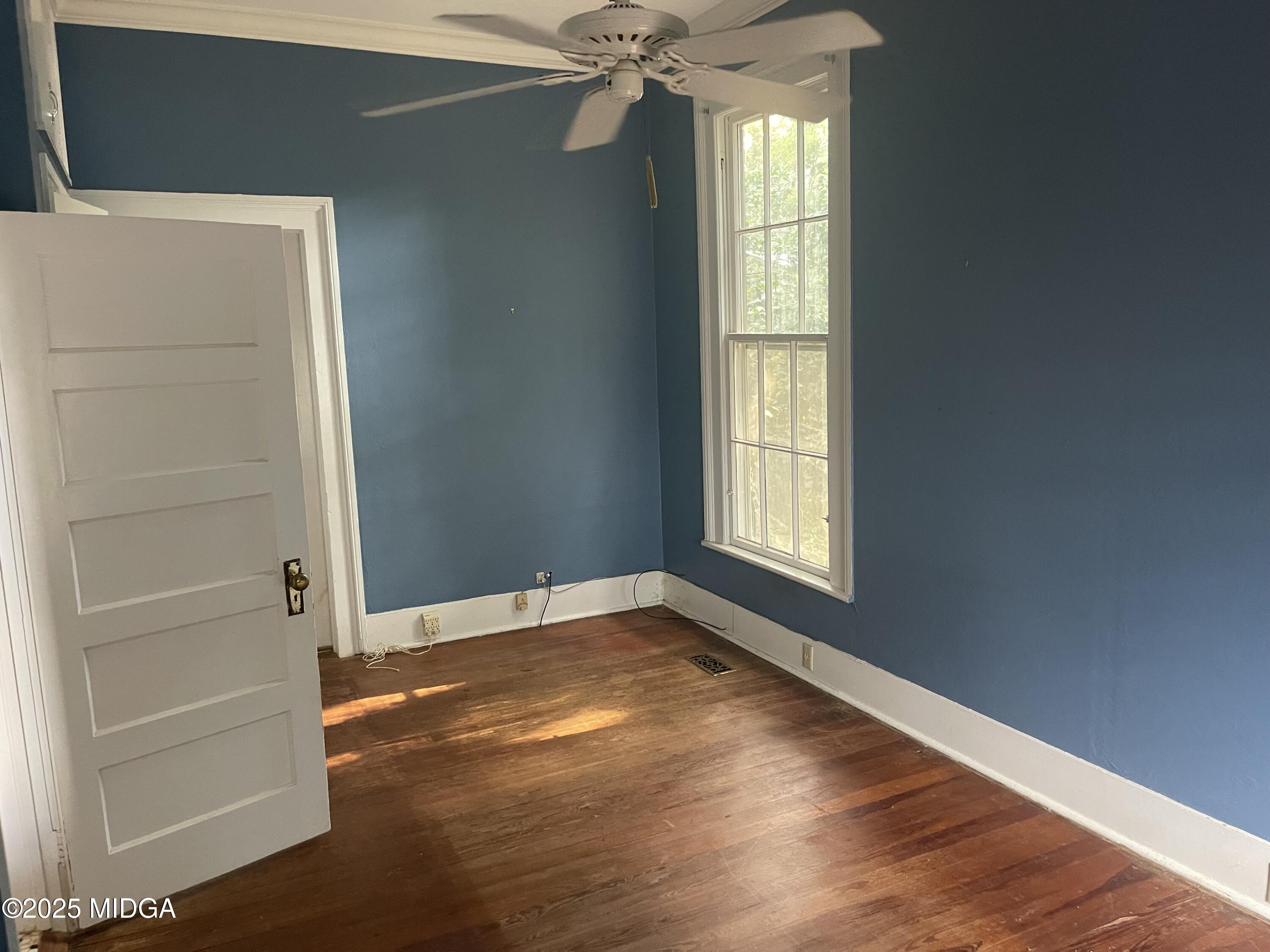 307 Woolfolk Road Fort Valley, GA 31030 - Photo 36 of 62 an empty room with wooden floor fan and windows