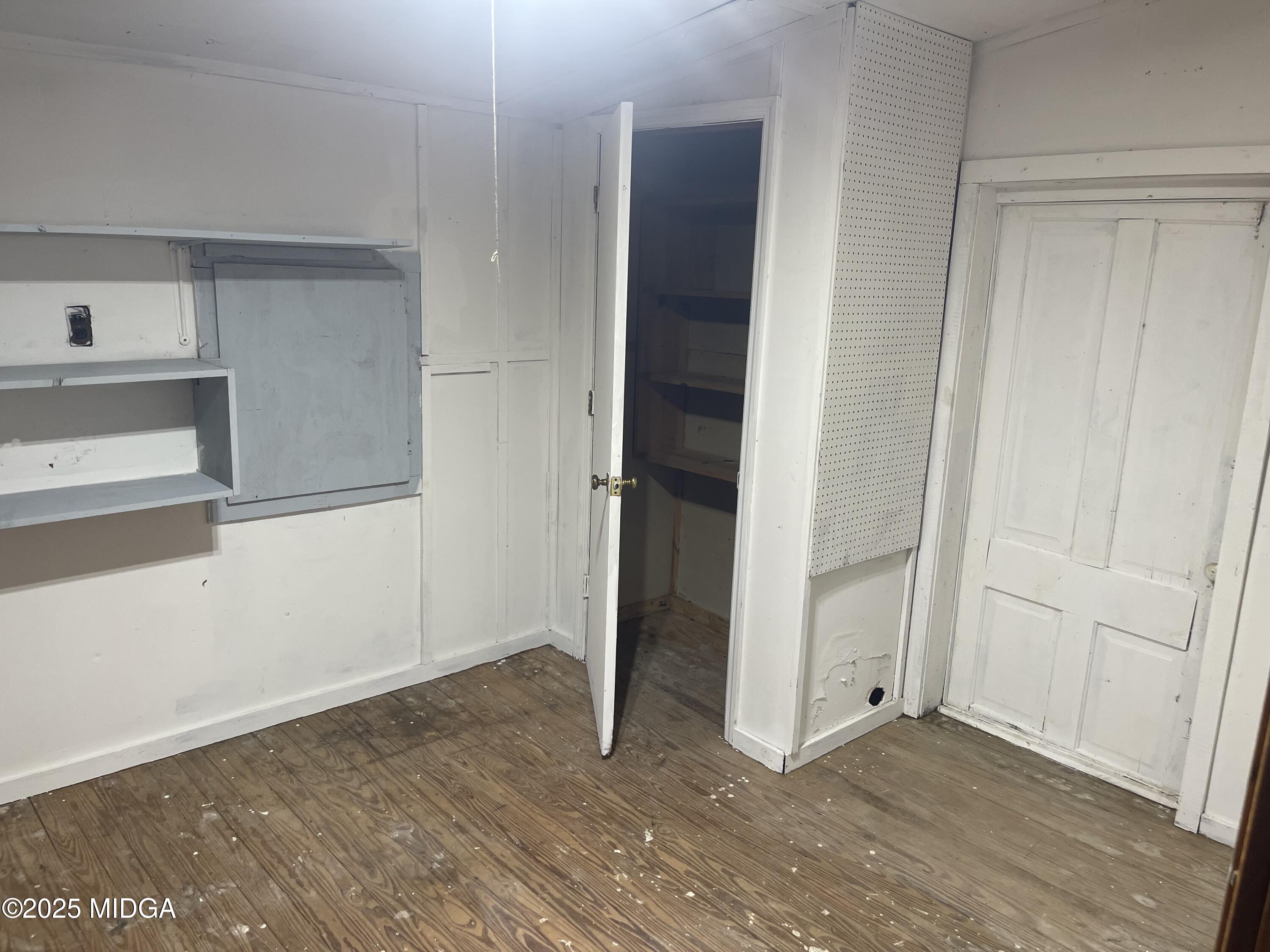 307 Woolfolk Road Fort Valley, GA 31030 - Photo 60 of 62 an empty room with wooden floor and cabinet