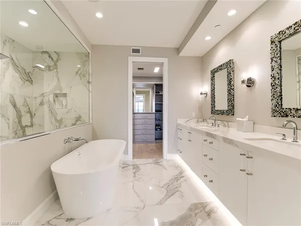 a spacious bathroom with a bathtub sink and mirror