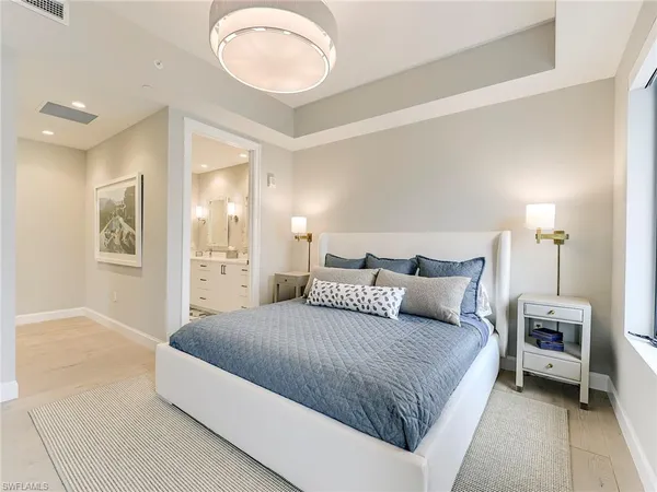 a bedroom with a large bed and a chandelier