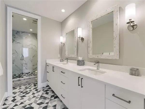 a bathroom with a double vanity sink mirror and shower
