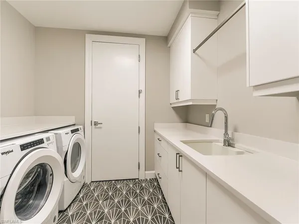a utility room with sink dryer and washer