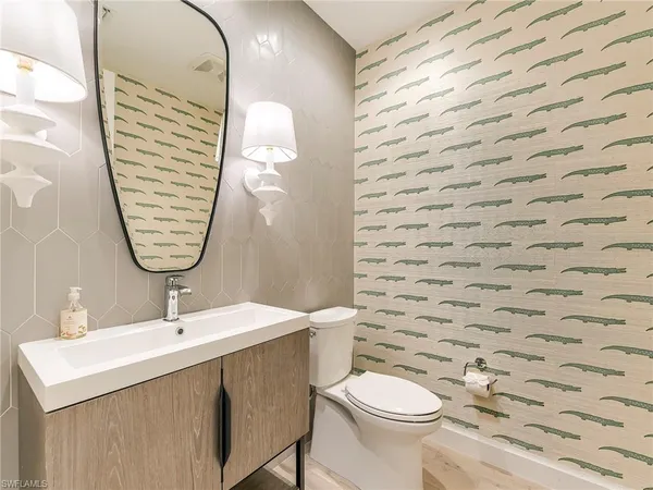 a bathroom with a sink a toilet and a mirror