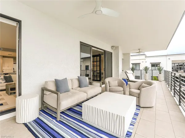 a living room with furniture a flat screen tv and white walls