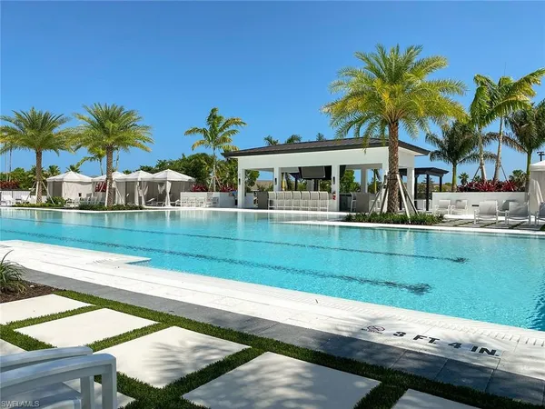 a view of a patio with couches and table with swimming pool and outdoor seating