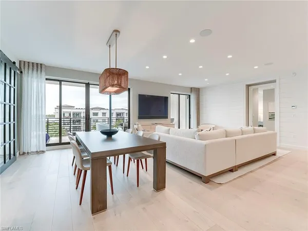 a living room with furniture a flat screen tv and a large window