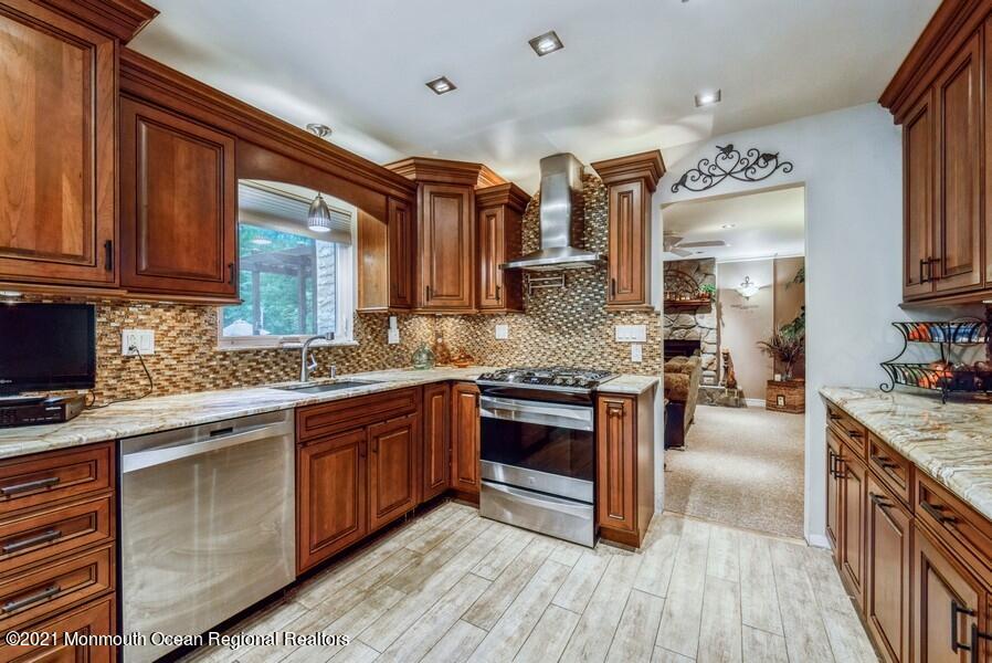 57 Millay Road Morganville, NJ 07751 - Photo 14 of 46 a kitchen with stainless steel appliances granite countertop a stove and cabinets