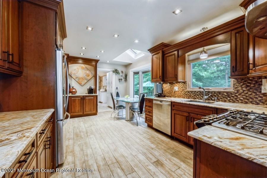 57 Millay Road Morganville, NJ 07751 - Photo 15 of 46 a kitchen with stainless steel appliances granite countertop sink stove top oven and cabinets
